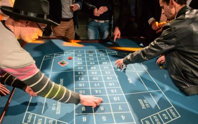 Colleagues around a roulette table during a casino night at a staff party