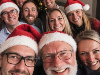 Des coll&egrave;gues avec des bonnets de No&euml;l font un selfie de groupe
