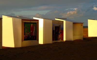 Kleurrijke strandcabines in Koksijde bij zonsondergang