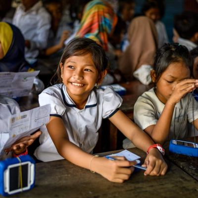 &Eacute;coliers souriants avec les lampes Solar Buddy que les &eacute;quipes assemblent pendant le team building